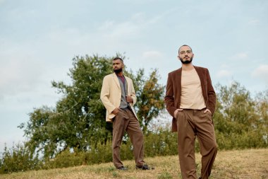 Yakışıklı erkekler, doğanın canlı renkleri arasında poz verirken modaya uygun sonbahar kıyafetlerini sergiliyorlar..