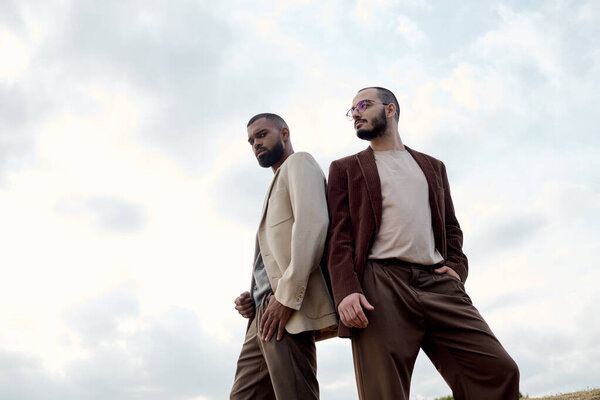 Красивые мужчины в модных осенних нарядах наслаждаются спокойным моментом в красивом поле.