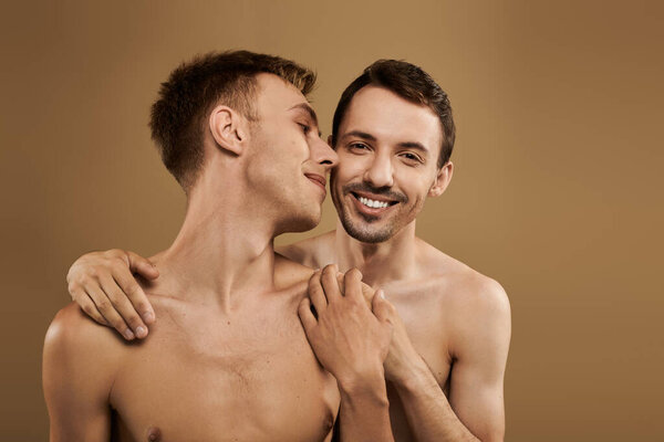 A happy young couple shares an intimate embrace, showcasing their love in a cozy atmosphere.