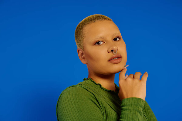 Уверенная в себе молодая женщина подчеркивает свой уникальный стиль и индивидуальность в творческом портрете.