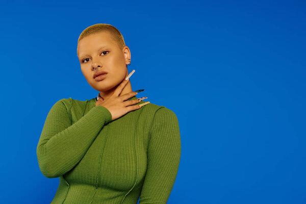 A young woman confidently poses in trendy attire, showcasing her bold style and unique features.