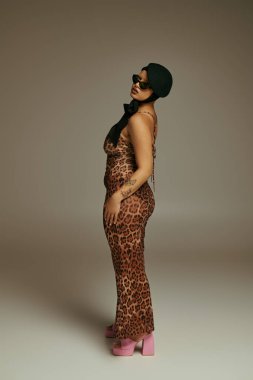 Modaya uygun genç bir kadın cesur stilini leopar desenli bir kıyafet ve pembe topuklularla ifade eder..