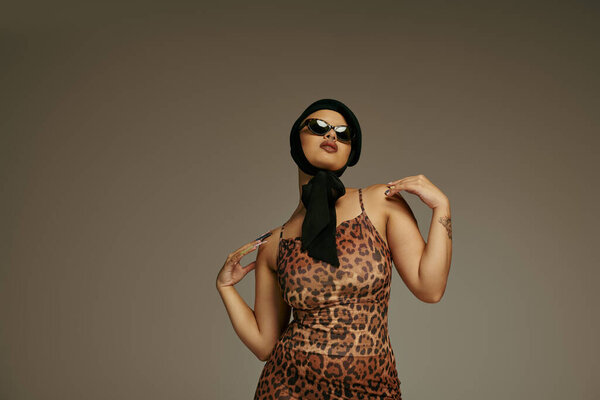 Молодая женщина демонстрирует свое чувство стиля, одетая в костюм леопарда и ставящая смелую позу.