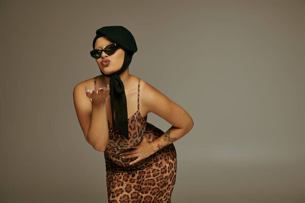 Уверенная в себе женщина ставит игривую позу, демонстрируя свой уникальный стиль и чувство современной моды.