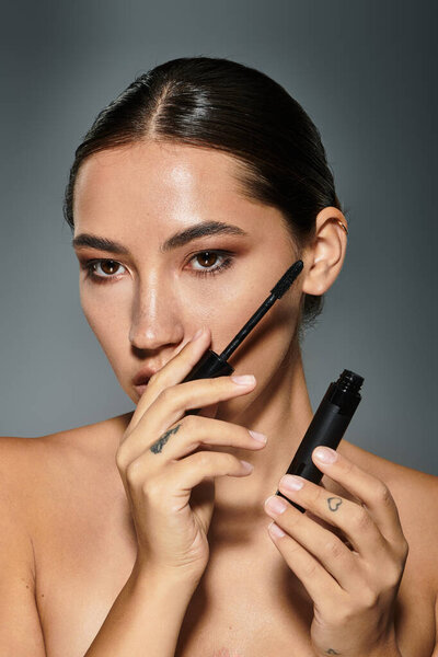 Опытный художник повышает свою природную красоту с помощью косметических инструментов, излучая уверенность.