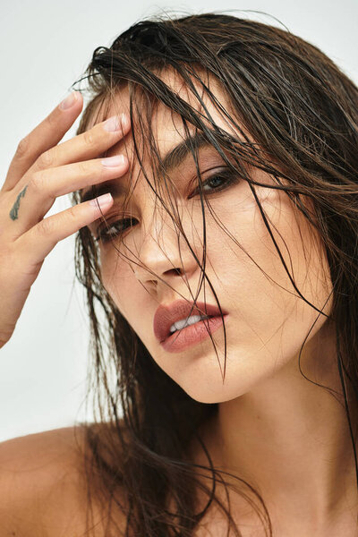 Это поразительное изображение захватывает женщину с мокрыми волосами, источая уверенность и очарование.