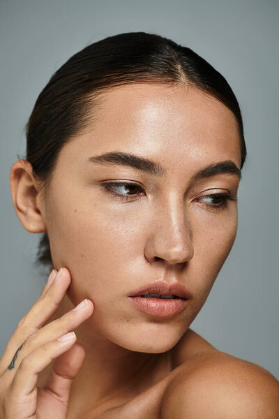 Потрясающая женщина задумчиво смотрит вдаль, демонстрируя свою безмятежную красоту и элегантность.