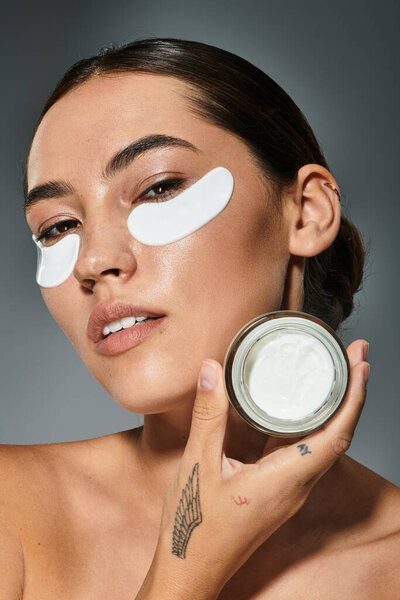 Изящная женщина применяет освежающий уход за кожей, подчеркивая свою природную красоту.