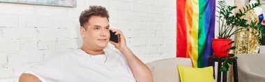 Eşcinsel bir kişi renkli dekorasyonlarla çevrili canlı bir telefon görüşmesi yapıyor..