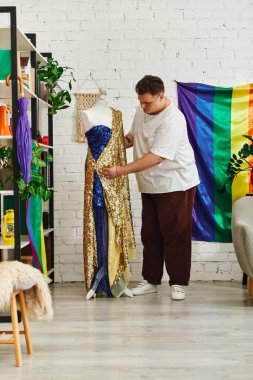 A creative individual adjusts a dazzling gown surrounded by pride themed decor in their studio. clipart