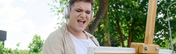 A queer person energetically expresses creativity outdoors, immersed in their art and music.