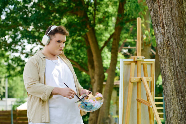 A unique artist expresses creativity while painting under a tree in a lively park setting