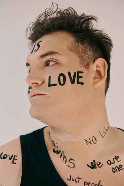 This queer person showcases their identity with expressive body art linked to love and unity.