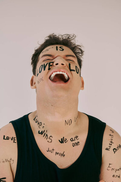 Странный человек с радостью демонстрирует свое бодибилдинговое искусство, пропагандируя любовь и единство..