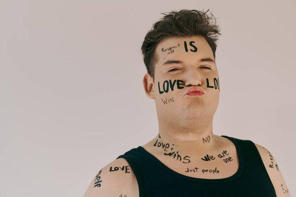 A captivating queer person displays messages of love and acceptance written on their body.