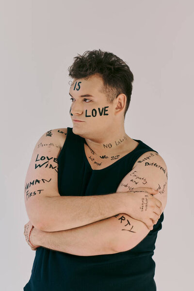 Странный человек уверенно стоит с содержательными посланиями, написанными на его руках и лице..