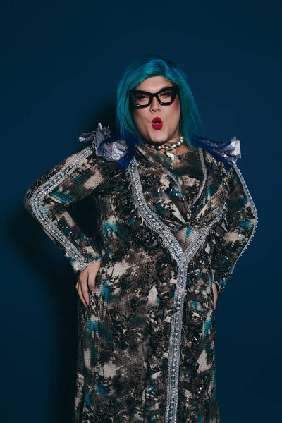 This vibrant individual exudes confidence with their dazzling outfit and distinctive blue hair.