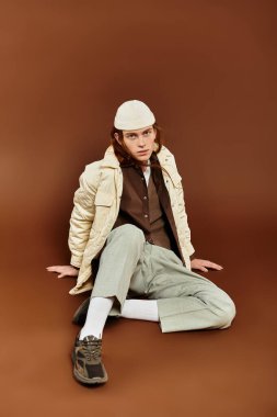 Çarpıcı kızıl saçlı genç bir çocuk, kendine güvenen modaya uygun bir şekilde poz veriyor, eşsiz tarzını sergiliyor..