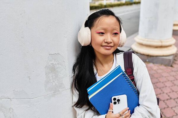A vibrant student happily embraces her university experience, showcasing youth culture and style.