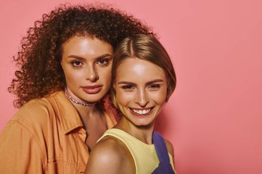 Neşeli bir lezbiyen çift birbirlerini kucaklıyor, neşeli bir stüdyo ortamında sevgi ve pozitiflik yayıyorlar..