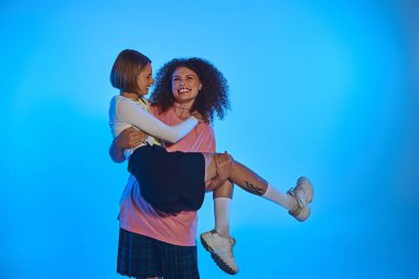 Renkli bir stüdyo ortamında birbirlerine sevgi ve çeşitlilik gösteren iki neşeli kadın..