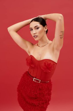 Güzel bir kadın dikkat çekici bir kırmızı elbiseyle moda anlayışını sergiliyor, kendine güveni tam..