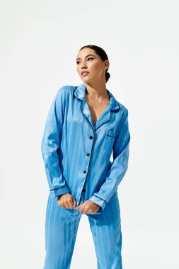 The young woman showcases fashionable blue pajamas, striking a confident pose with grace. clipart