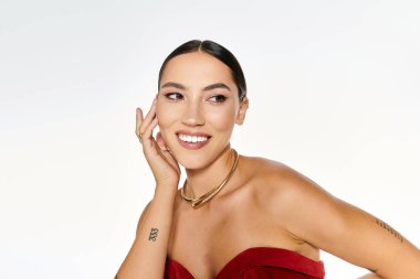 Genç ve güzel bir kadın, ışıl ışıl gülüşünü ve zarif bakışlarını yumuşak bir arka plana karşı sergiliyor..