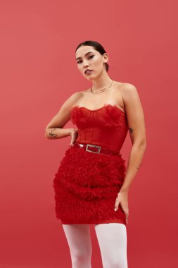 Bu genç kadın moda anlayışını cesur kırmızı bir kıyafet ve dikkat çekici bir özgüvenle gösteriyor..