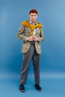 Şık kış kıyafetleri içinde genç ve yakışıklı bir adam kendinden emin bir şekilde poz veriyor, zahmetsiz bir şekilde..