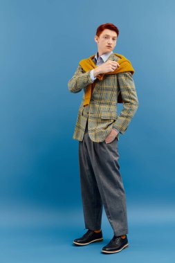 Şık bir genç adam kendine güvenerek poz veriyor, şık katmanlı bir kış kıyafetiyle gösteriş yapıyor..