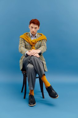 Kızıl saçlı yakışıklı bir adam zarif bir kış elbisesi giymiş, kendine güveni tam..