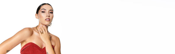 Эта потрясающая молодая женщина демонстрирует уверенность и красоту с изящной позой, излучающей элегантность.