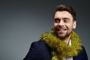 Yakışıklı genç bir adam, kutlama çelengi takarken mutluluk saçar..