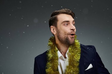 A young man expresses delight while celebrating with festive decorations in a winter atmosphere. clipart