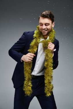 This handsome man in formal wear joyfully embraces a festive atmosphere with gold decorations clipart