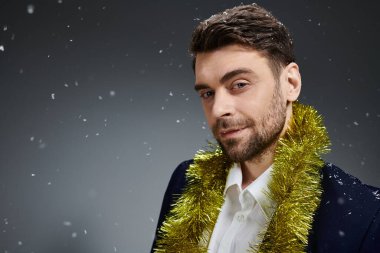 Sakallı çekici bir genç adam, mevsimlik dekorlarla süslenirken neşeli bir atmosferin tadını çıkarıyor..