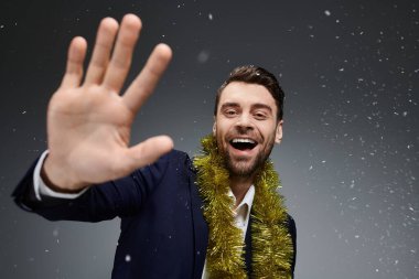 Şenlikli bir tatil çelengiyle süslenmiş, büyük bir gülümsemesi olan yakışıklı bir genç adam..