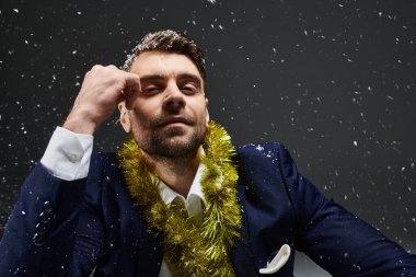 Şık bir adam neşeli kış mevsimini tavırlarıyla kucaklarken neşeli bir kolye takar.