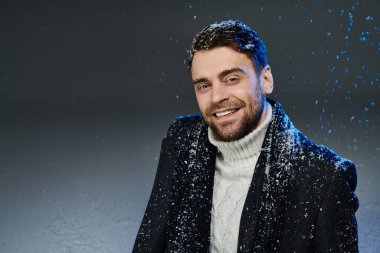 Yakışıklı genç bir adam kışın yavaşça omuzlarına düşen kar taneleri gibi gülümsüyor..