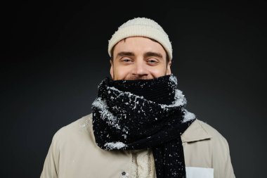 Kalın bir atkı ve kalın giysiler giyen bu mutlu genç adam kış havasını neşeyle kucaklıyor..