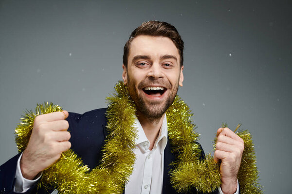 A handsome young man gleefully holds colorful decorations with joy and excitement.