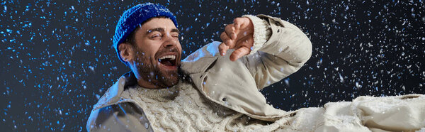 Молодой человек радостно смеется, окруженный нежными снежинками, излучающими тепло и счастье..