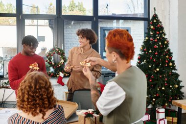 İş arkadaşları, işyerlerinde birlikte Noel 'i kutlarken pizza yiyip kahkaha atıyorlar..