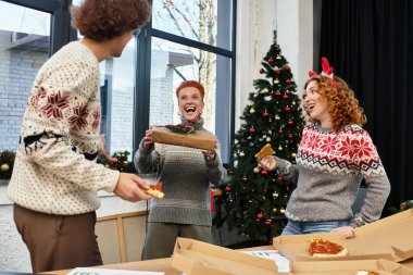 Noel 'i neşeli ofis atmosferinde kutlarken meslektaşlar kahkaha ve pizzayı paylaşıyor..