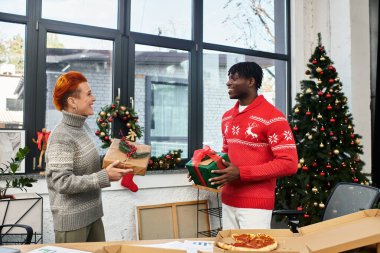 İki iş arkadaşı ofislerinde neşeli bir Noel kutlaması sırasında birbirlerine hediye verirler..