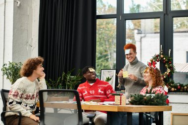 Genç iş arkadaşları Noel 'i şenlikli dekorasyonların ortasında neşeyle kutluyorlar.