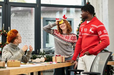 Team members share laughter and festive cheer while exchanging gifts during Christmas. clipart