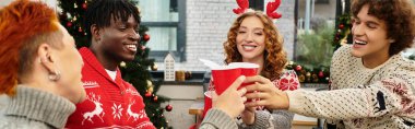 Neşeli iş arkadaşları kutlama bardaklarıyla kadeh kaldırır ve Noel kutlamalarında gülerler..