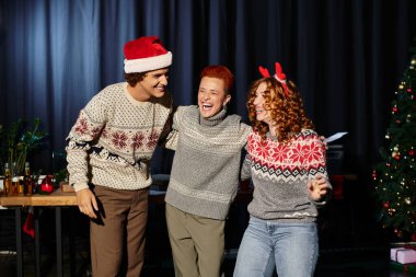 Young coworkers are joyfully celebrating Christmas together in a decorated office environment. clipart